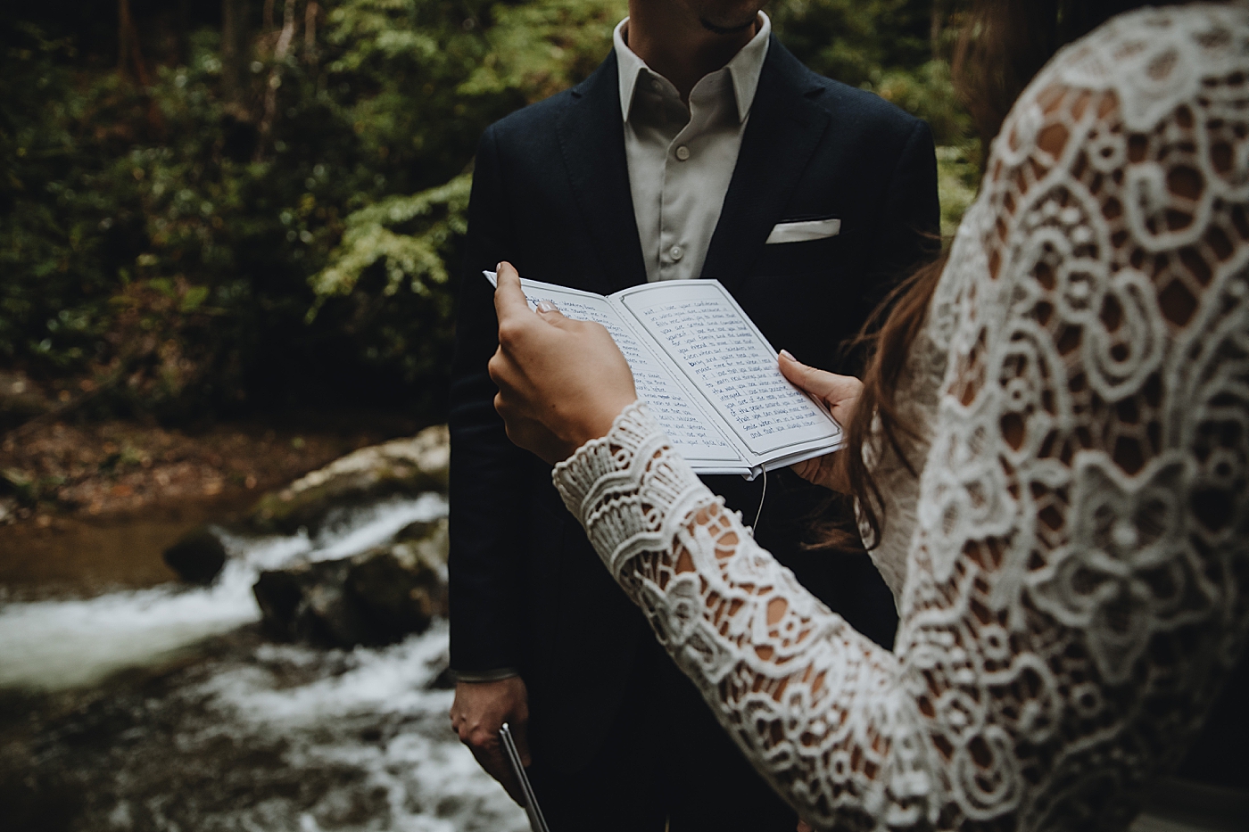 Bride giving vows with closeup of vow book Catawba Falls Asheville, NC Elopement Photography captured by Maggie Alvarez Photography