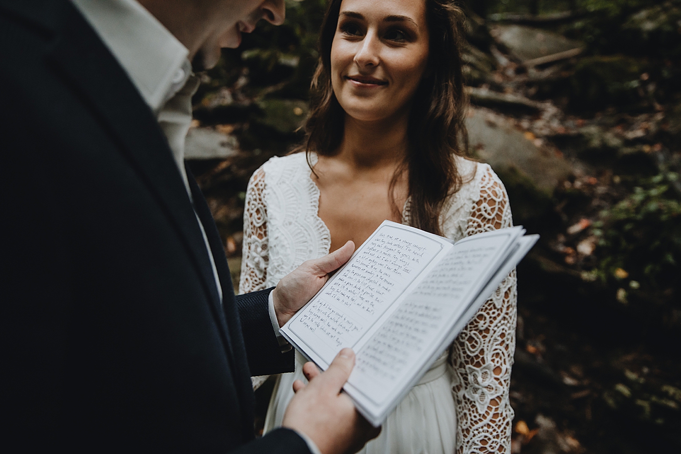 Bride smiling as Groom gives vows with vow book Catawba Falls Asheville, NC Elopement Photography captured by Maggie Alvarez Photography
