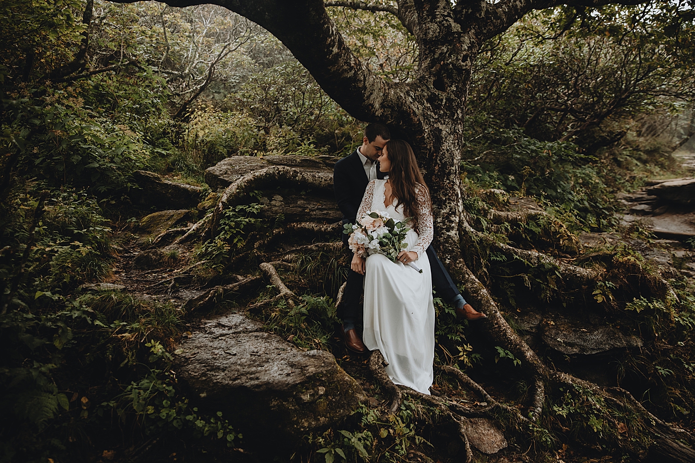 Bride and Groom nuzzling by tree in forest Catawba Falls Asheville, NC Elopement Photography captured by Maggie Alvarez Photography