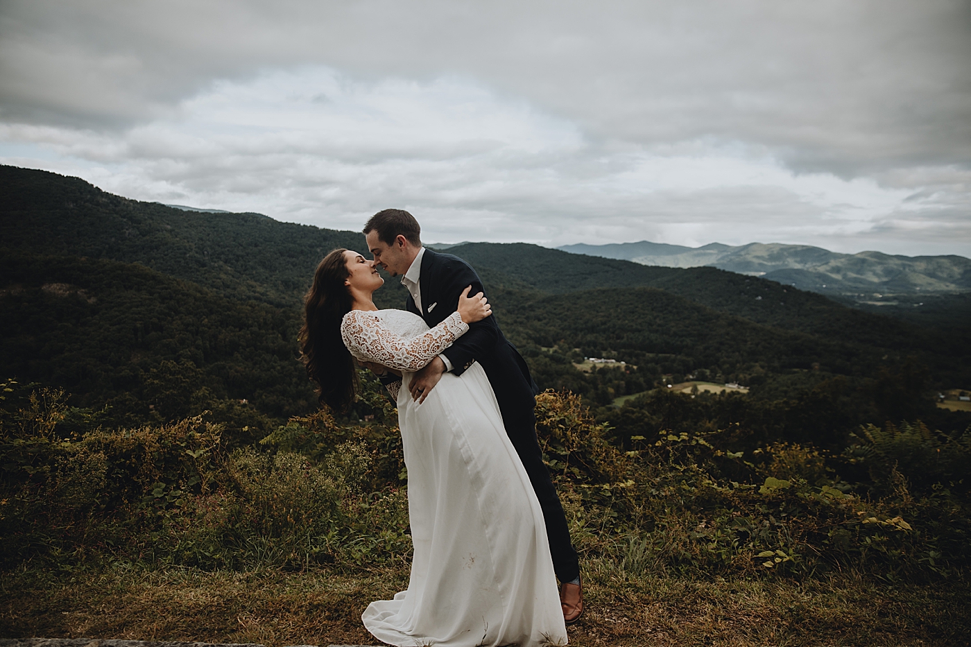 Bride and Groom dipping with mountains behind them Catawba Falls Asheville, NC Elopement Photography captured by Maggie Alvarez Photography