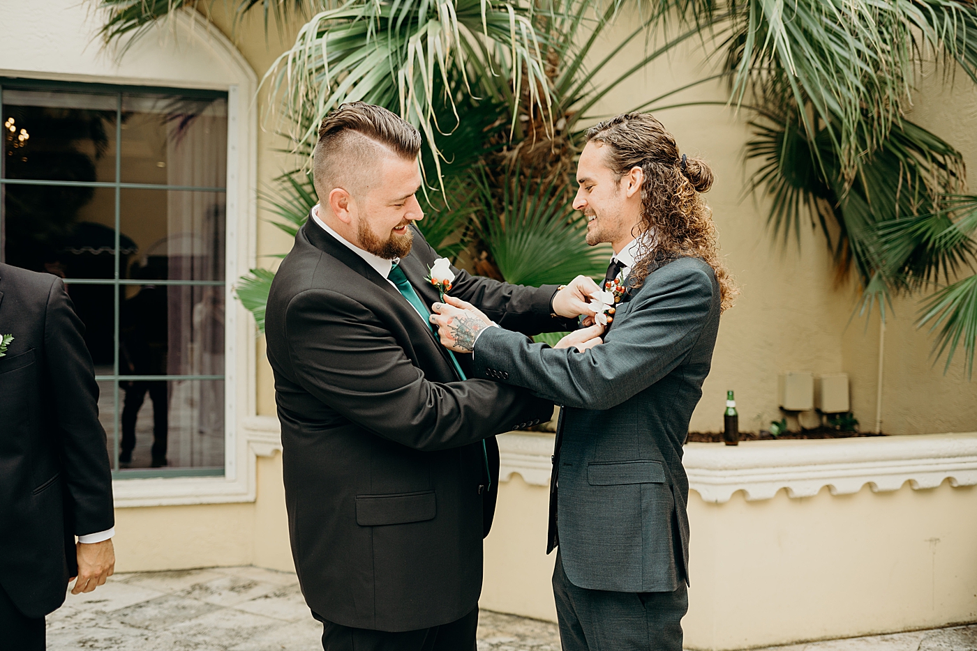 Groom and groomsmen helping putting on boutonnieres Benvenuto Restaurant Wedding Photography captured by South Florida Wedding Photographer Maggie Alvarez Photography