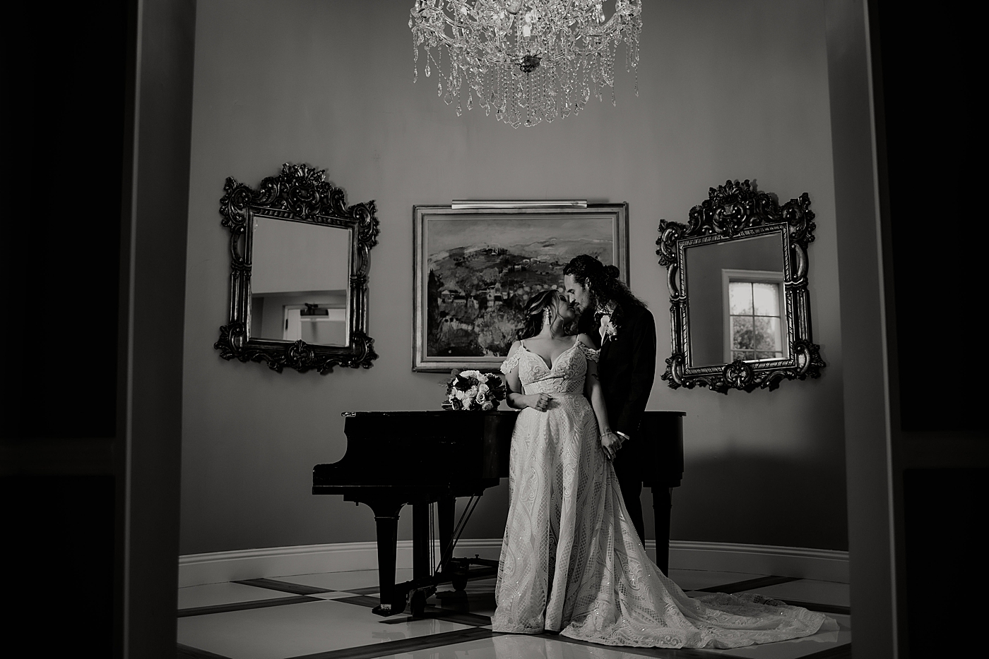 B&W Bride and Groom kissing with grand piano Benvenuto Restaurant Wedding Photography captured by South Florida Wedding Photographer Maggie Alvarez Photography