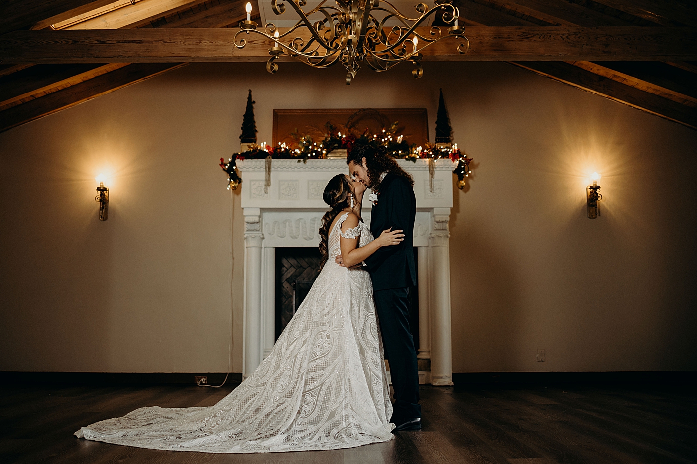 Bride and Groom kissing inside in front of fireplace with Christmas decor Benvenuto Restaurant Wedding Photography captured by South Florida Wedding Photographer Maggie Alvarez Photography