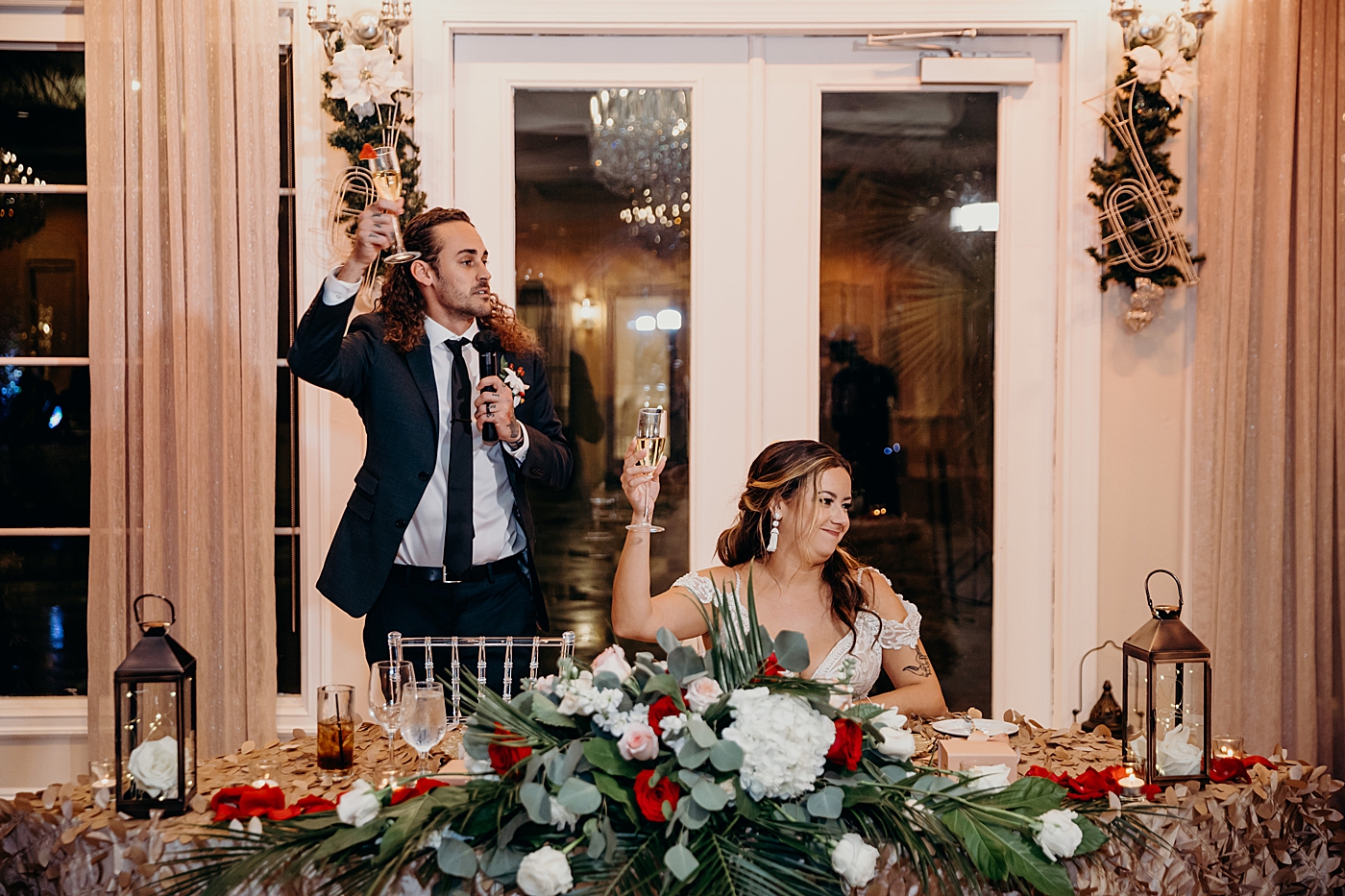 Groom holding cheers by sweetheart table Benvenuto Restaurant Wedding Photography captured by South Florida Wedding Photographer Maggie Alvarez Photography