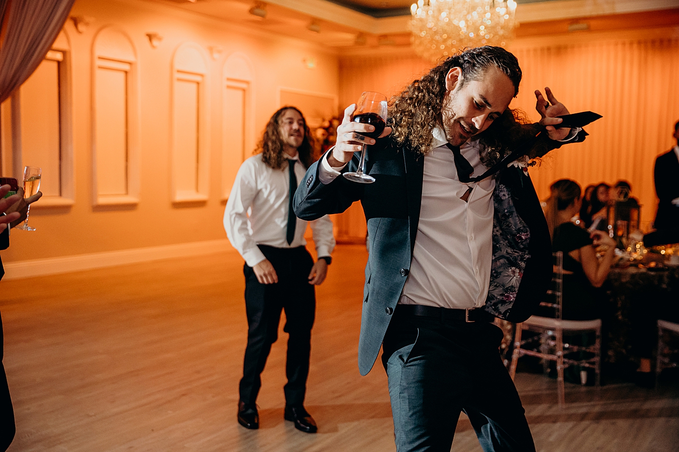 Groom dancing with glass of red wine at reception Benvenuto Restaurant Wedding Photography captured by South Florida Wedding Photographer Maggie Alvarez Photography