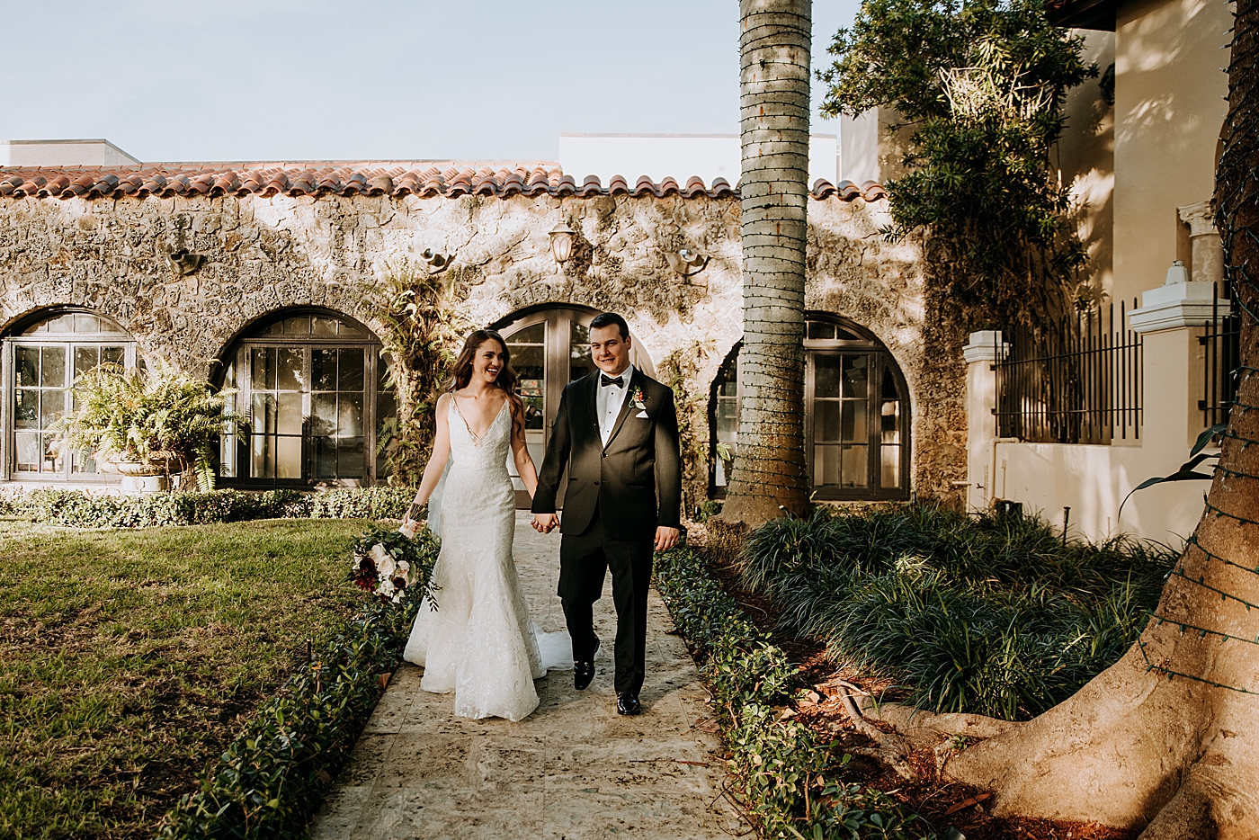 Bride and Groom holding hands walking down path Coral Gables Country Club Wedding Photography captured by South Florida Wedding Photographer Maggie Alvarez Photography