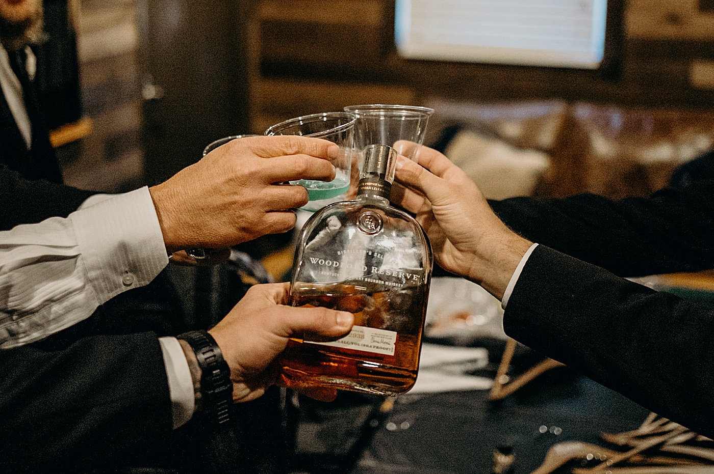 Getting ready with shots of liquor and whiskey Ever After Farms Wedding Photography captured by South Florida Wedding Photographer Maggie Alvarez Photography