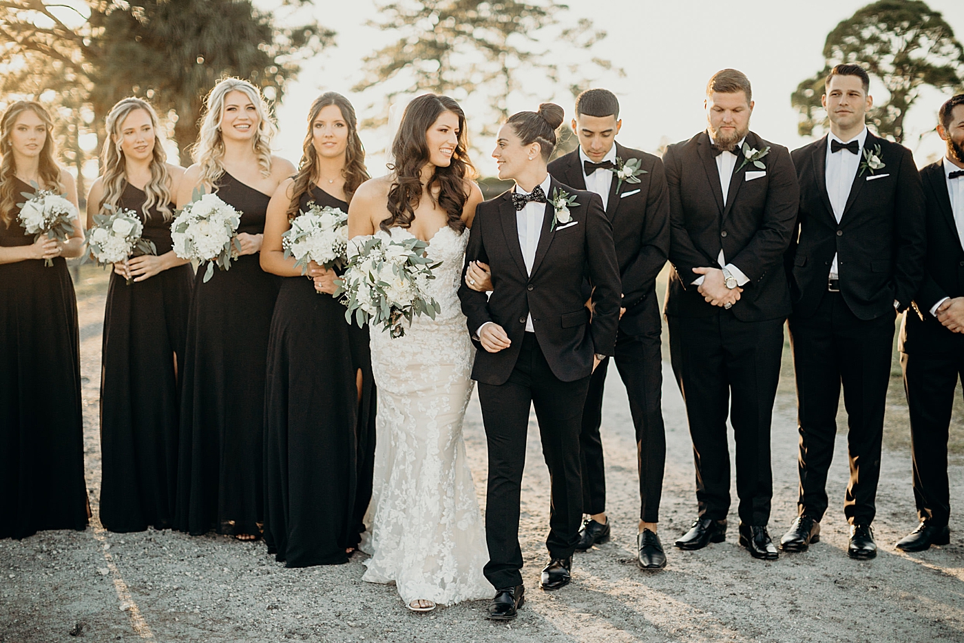 Brides with wedding party behind them Ever After Farms Wedding Photography captured by South Florida Wedding Photographer Maggie Alvarez Photography
