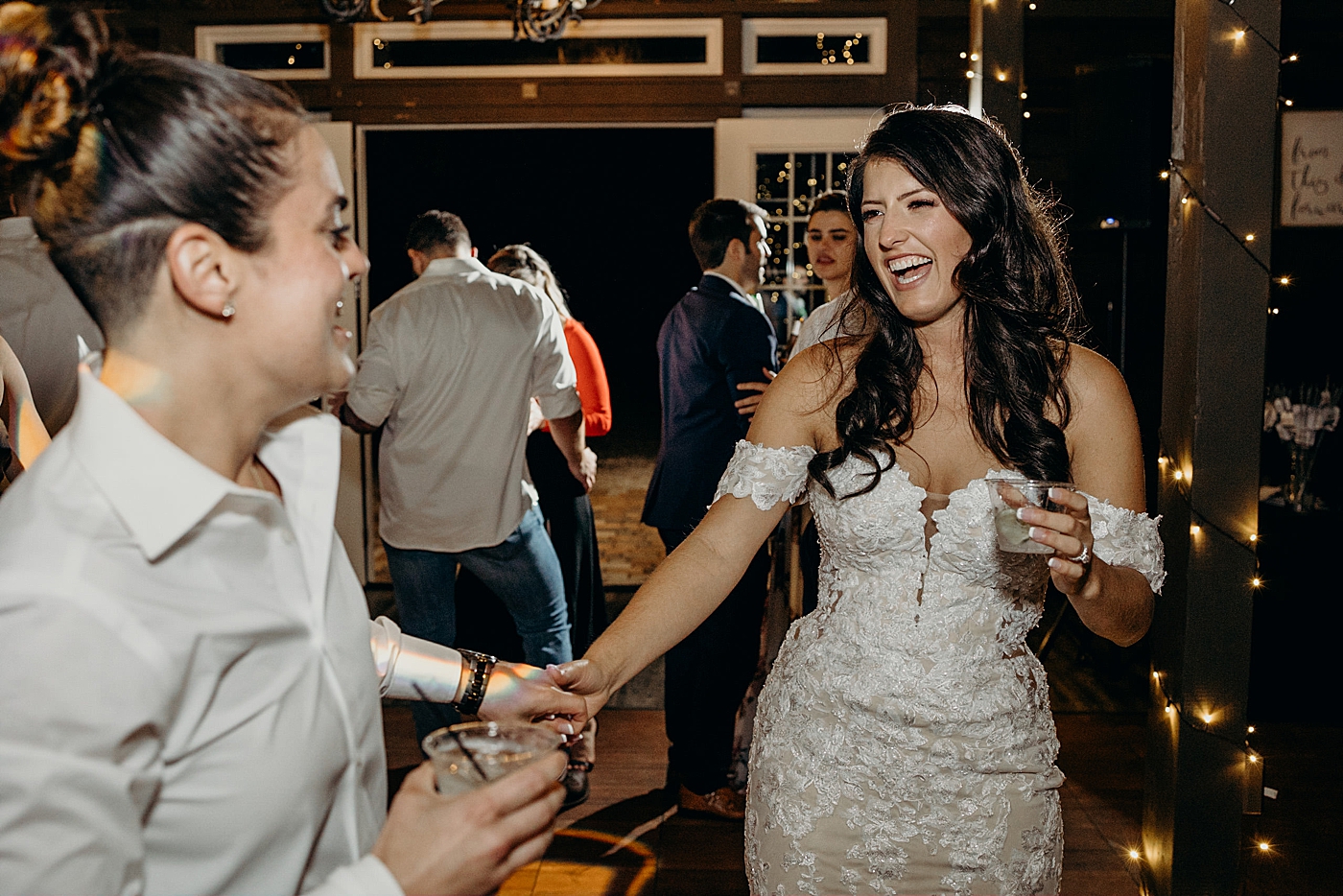 Brides having a drink while out on dance floor at reception Ever After Farms Wedding Photography captured by South Florida Wedding Photographer Maggie Alvarez Photography