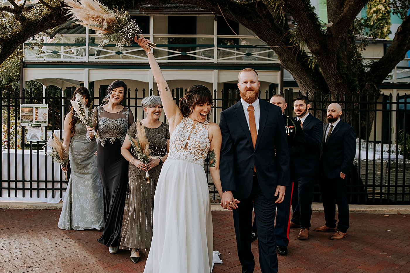 Bride and Groom walking together with Bridal party following behind Historic Stranahan House Wedding Photography captured by South Florida Wedding Photographer Maggie Alvarez Photography