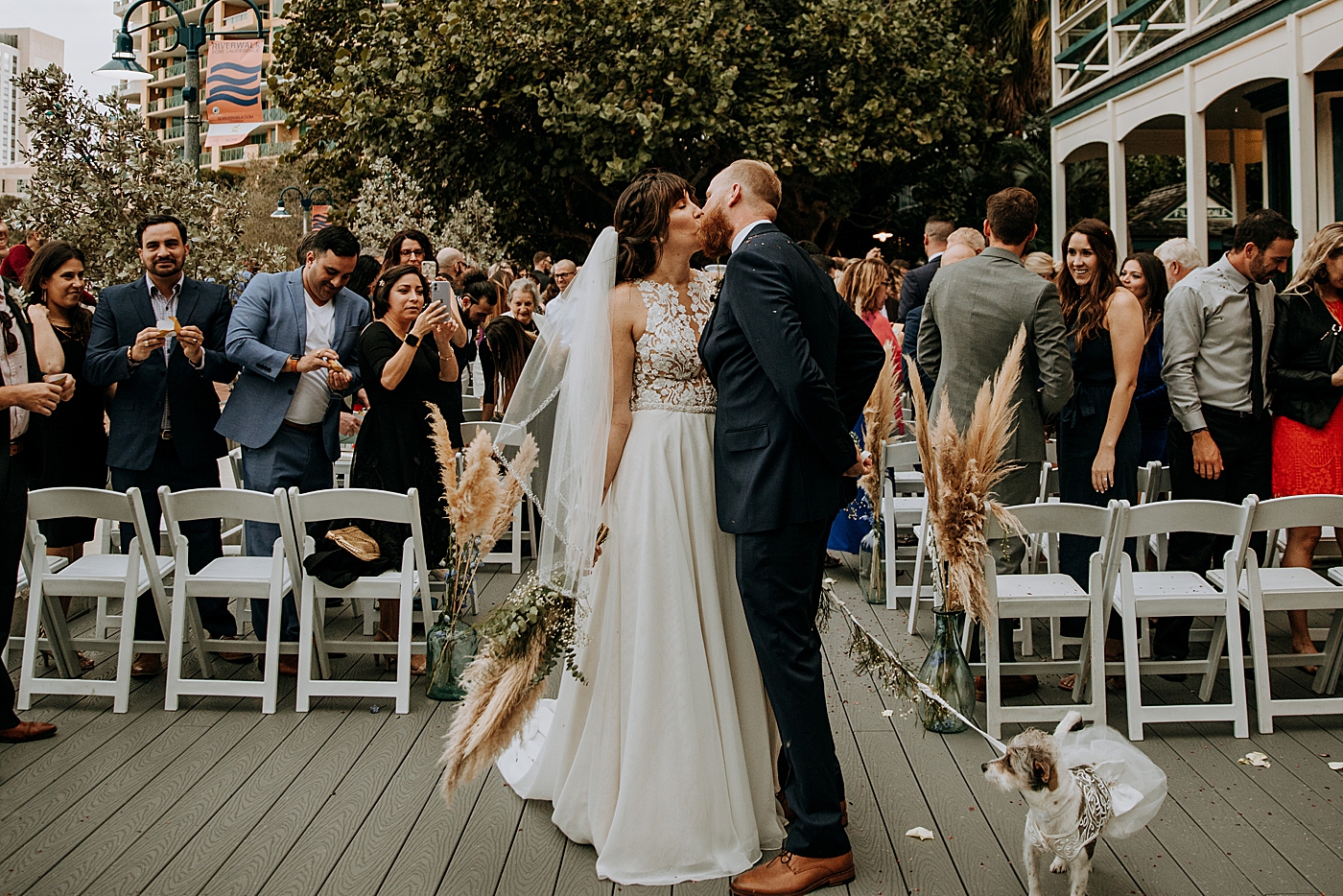 Bride and Groom kissing each other with wedding dog Historic Stranahan House Wedding Photography captured by South Florida Wedding Photographer Maggie Alvarez Photography