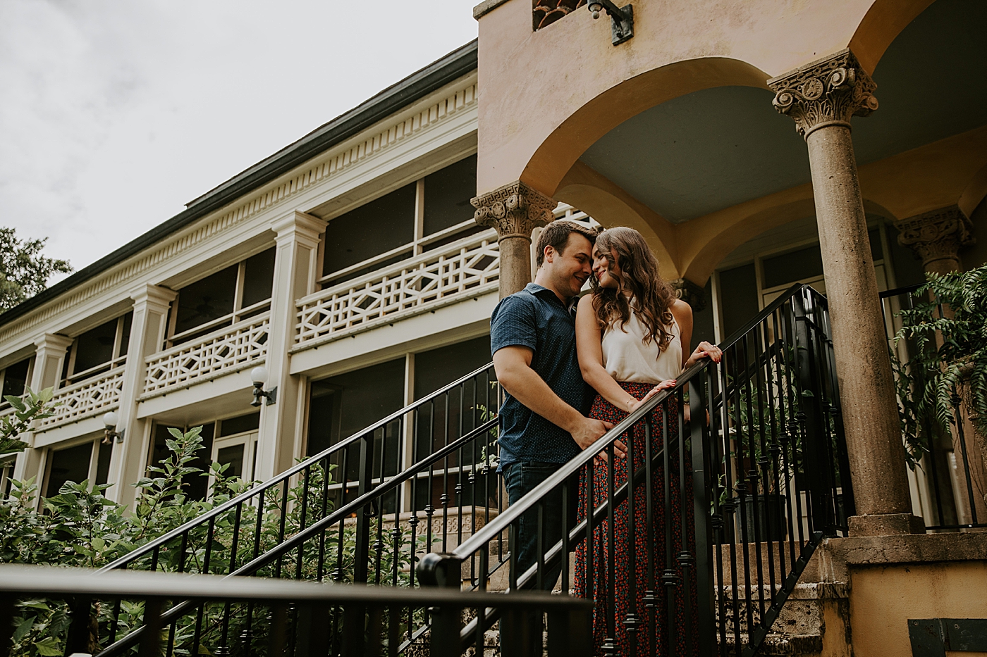 Couple nuzzling by staircase Deering Estate Engagement Photography captured by Maggie Alvarez Photography