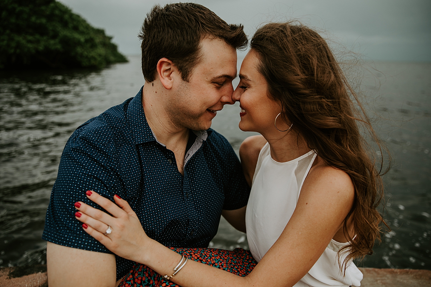 Couple holding each other by the water nuzzling their noses Deering Estate Engagement Photography captured by Maggie Alvarez Photography