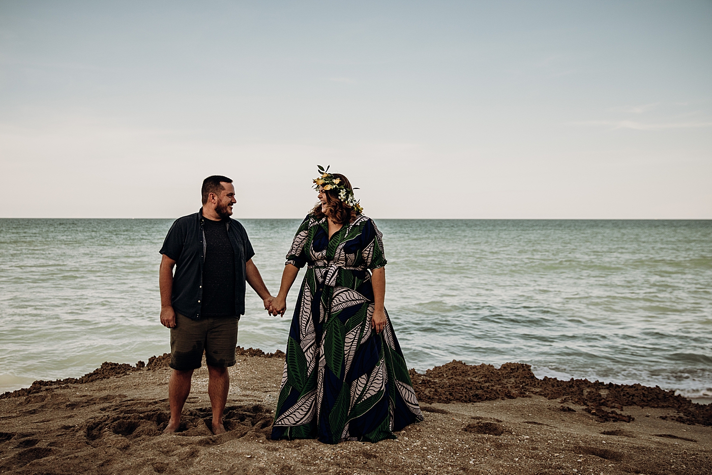 Couple holding hands in front of Oceanside on sand House of Refuge Engagement Photography captured by Maggie Alvarez Photography