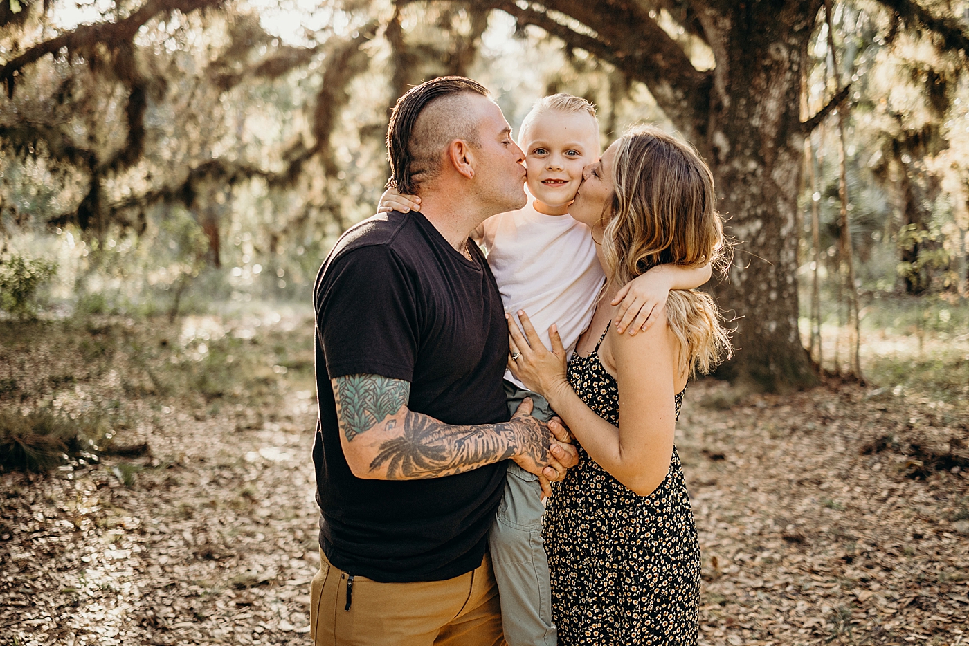 Parents hold child up and kiss them on the cheek Riverbend Park Family Photography by South Florida Family Photographer Maggie Alvarez Photography