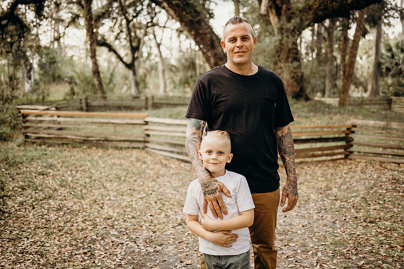 Dad holding son out by fence Park Family Photography by South Florida Family Photographer Maggie Alvarez Photography