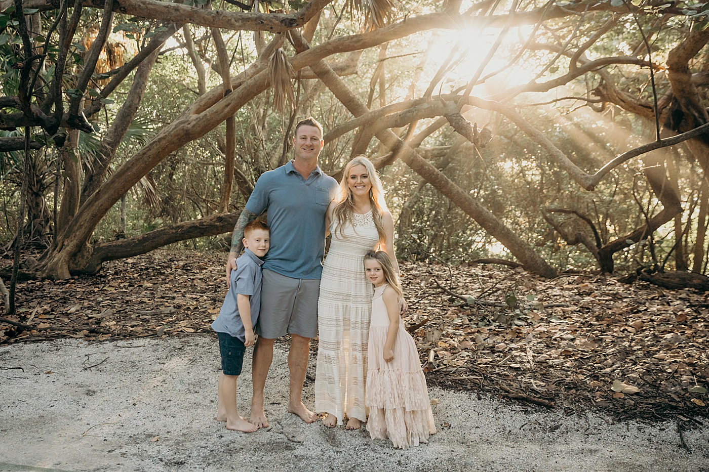 Family standing together with the sun breaking through Ocean Ridge Hammock Park Family Photography by South Florida Family Photographer Maggie Alvarez Photography