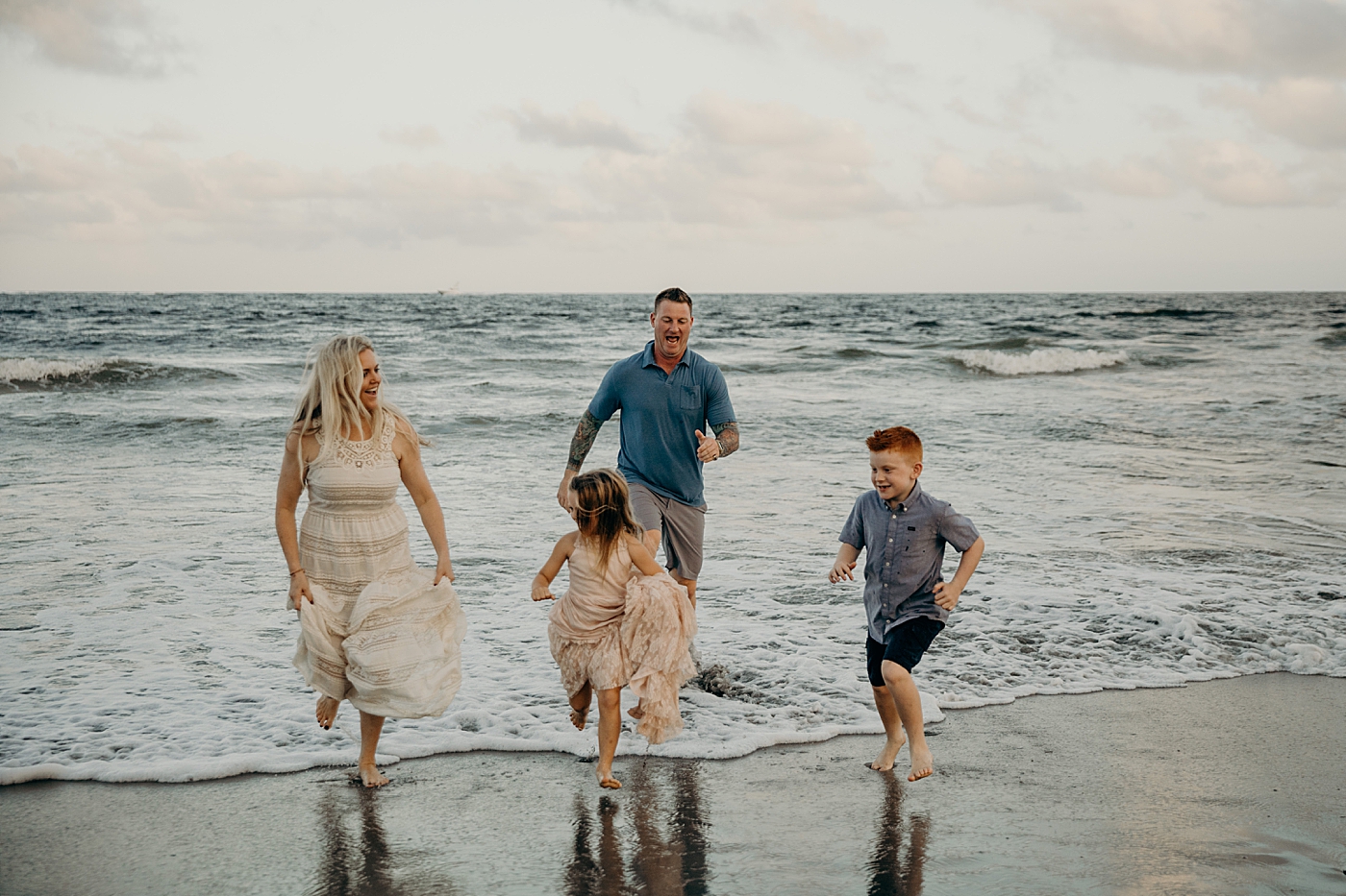Family running away from the water coming in on the beach Ocean Ridge Hammock Park Family Photography by South Florida Family Photographer Maggie Alvarez Photography