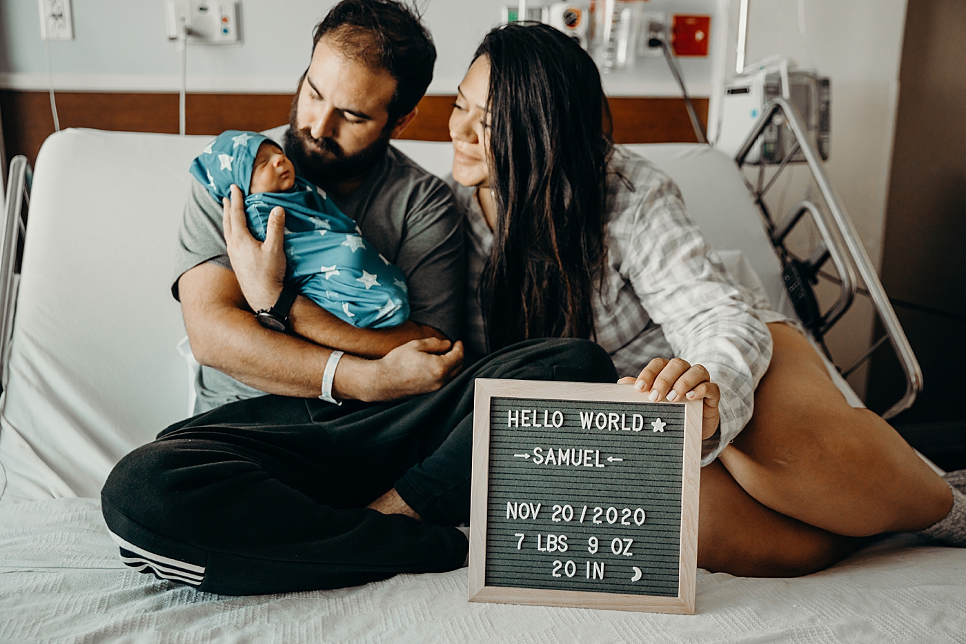 Dad holding baby with Mother holding "Hello World" sign South Florida Fresh 48 Newborn Photography by South Florida Family Photographer Maggie Alvarez Photography