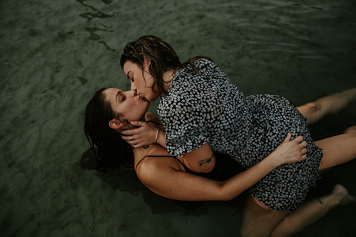 Woman on top of lady kissing each other in the water South Florida LGBTQ+ Engagement Photography captured by Maggie Alvarez Photography