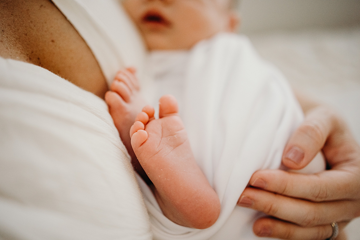 close up of baby's feet being held by mom South Florida Newborn Photography captured by South Florida Family Photographer Maggie Alvarez Photography