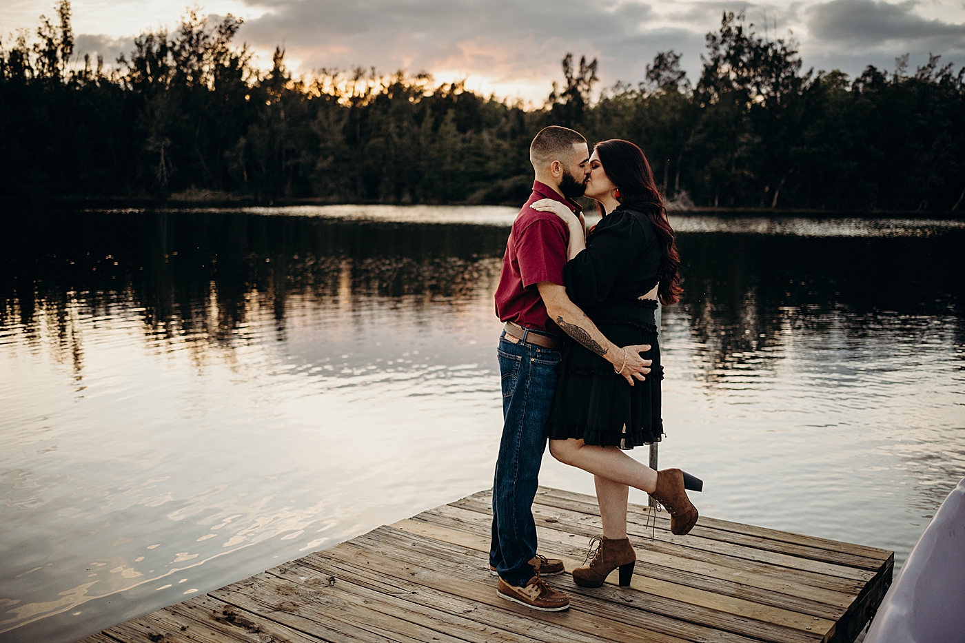 Couple kissing on the dock by the lake Tree Top Park Engagement Photography captured by Maggie Alvarez Photography