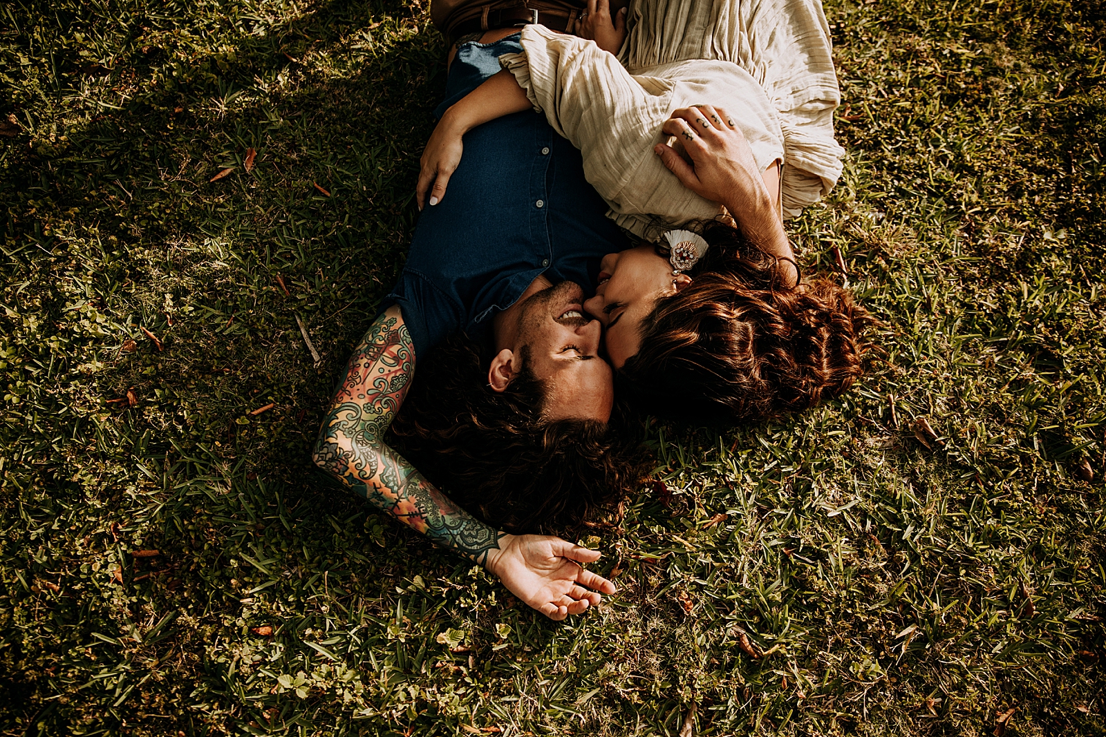 Couple laying down on the grass together nuzzling Dubois Park Engagement Photography captured by South Florida Family Photographer Maggie Alvarez Photography