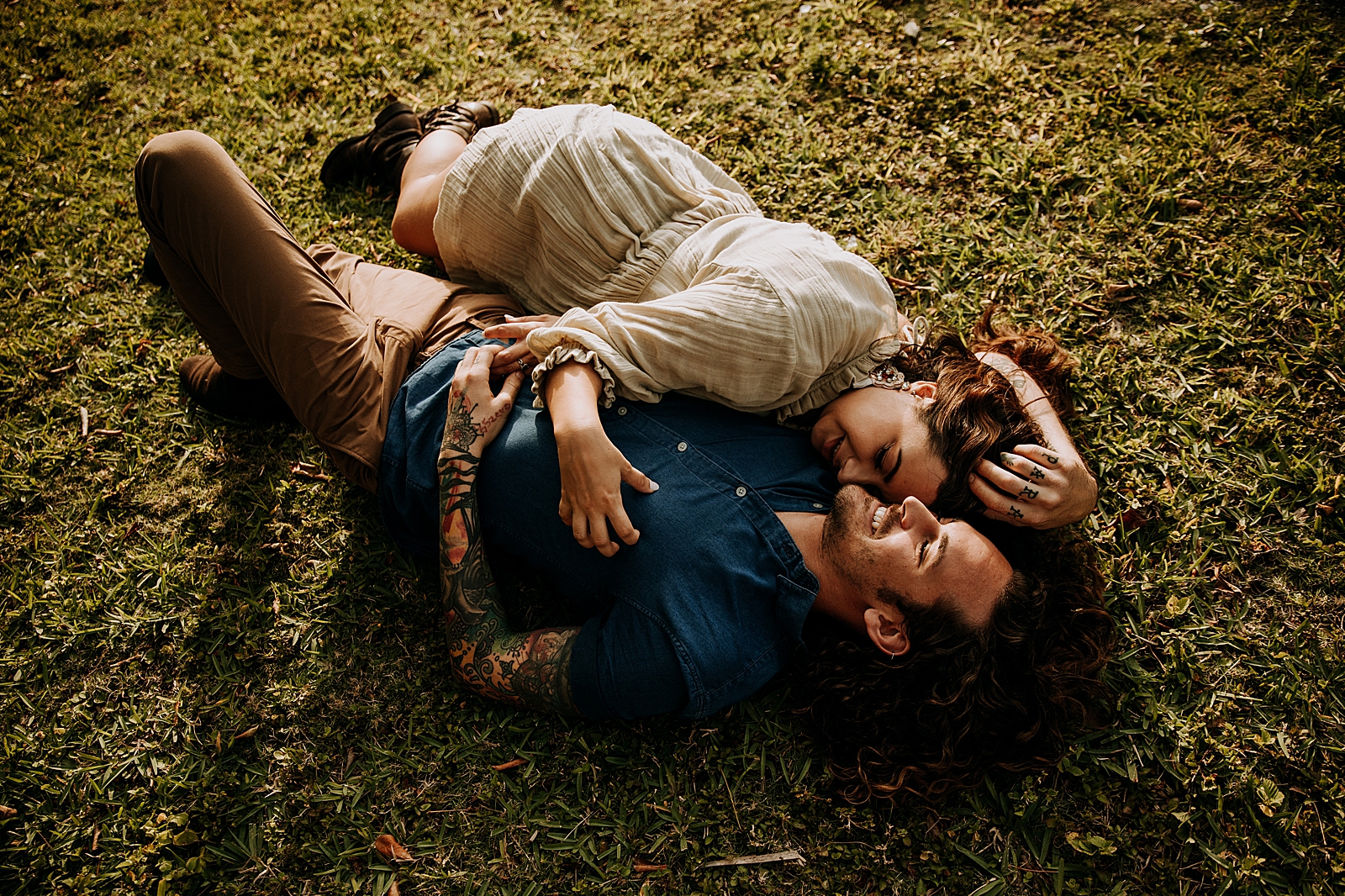 Lady holding man as they lay on the grass together Dubois Park Engagement Photography captured by South Florida Family Photographer Maggie Alvarez Photography