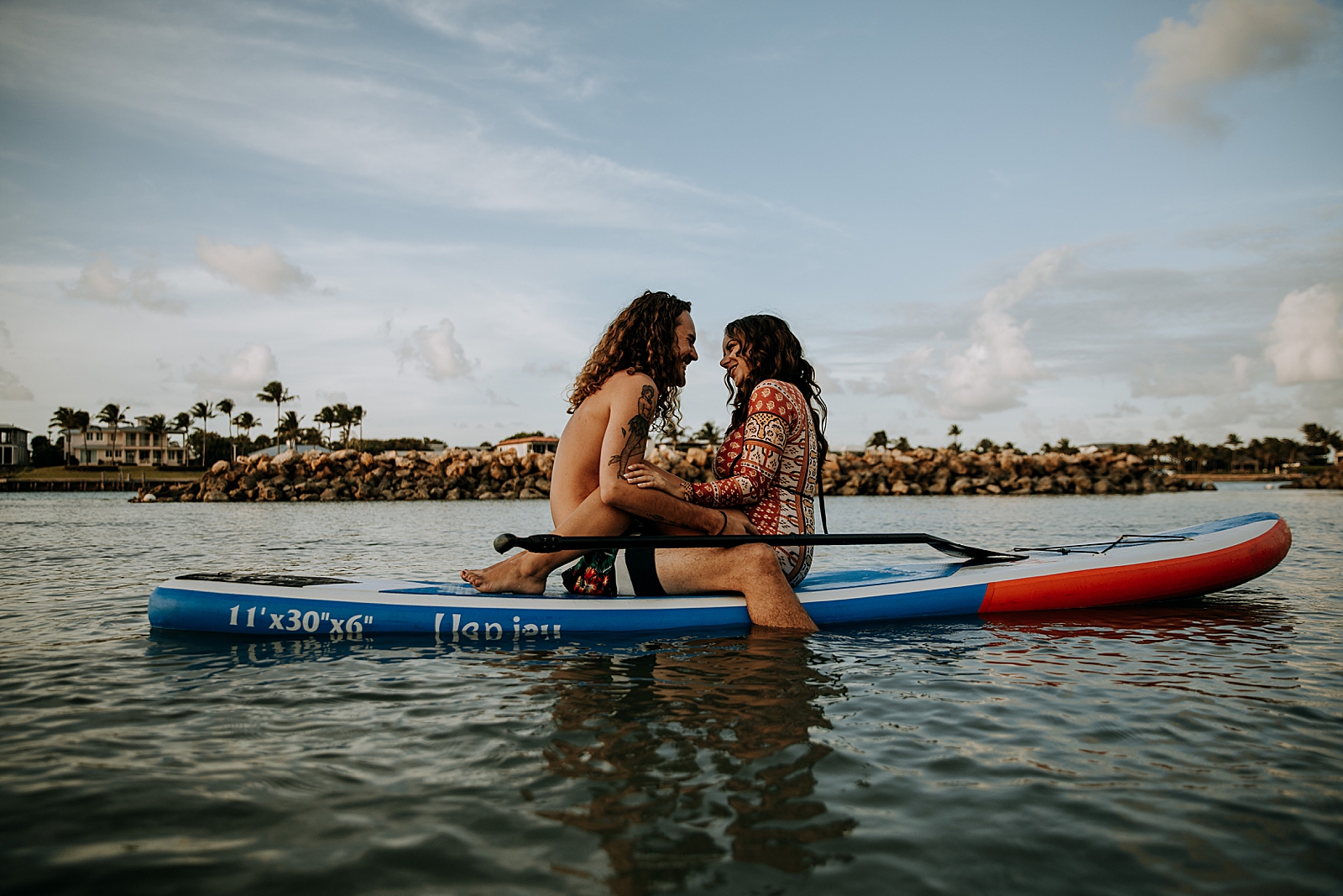 Couple sitting on canoe together on calm clear water Dubois Park Engagement Photography captured by South Florida Family Photographer Maggie Alvarez Photography