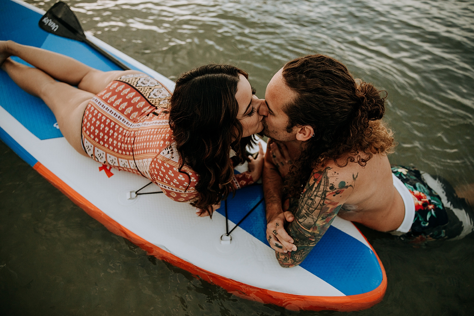Couple kissing on water and paddle board Dubois Park Engagement Photography captured by South Florida Family Photographer Maggie Alvarez Photography