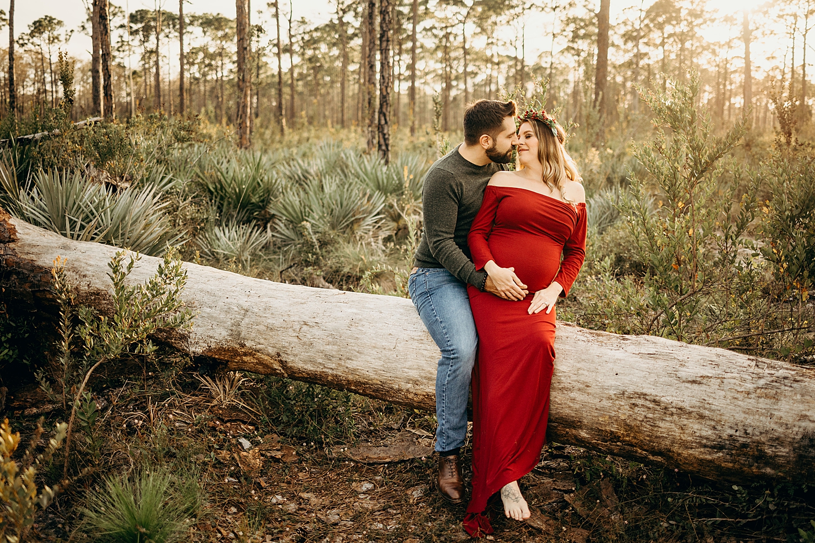 Couple sitting on fallen tree about to kiss Johnathan Dickinson Park Maternity Photography captured by South Florida Family Photographer Maggie Alvarez Photography