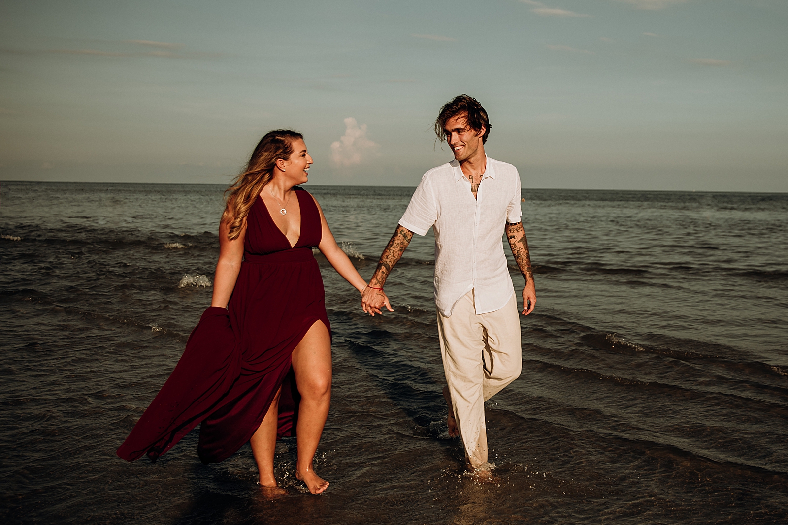 Couple holding hands walking in shallow ocean water Key Biscayne Beach Engagement Photography captured by South Florida Family Photographer Maggie Alvarez Photography