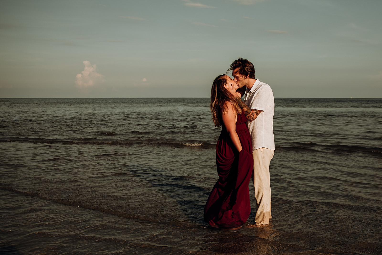 Couple holding each other kissing in the shallow ocean water Key Biscayne Beach Engagement Photography captured by South Florida Family Photographer Maggie Alvarez Photography