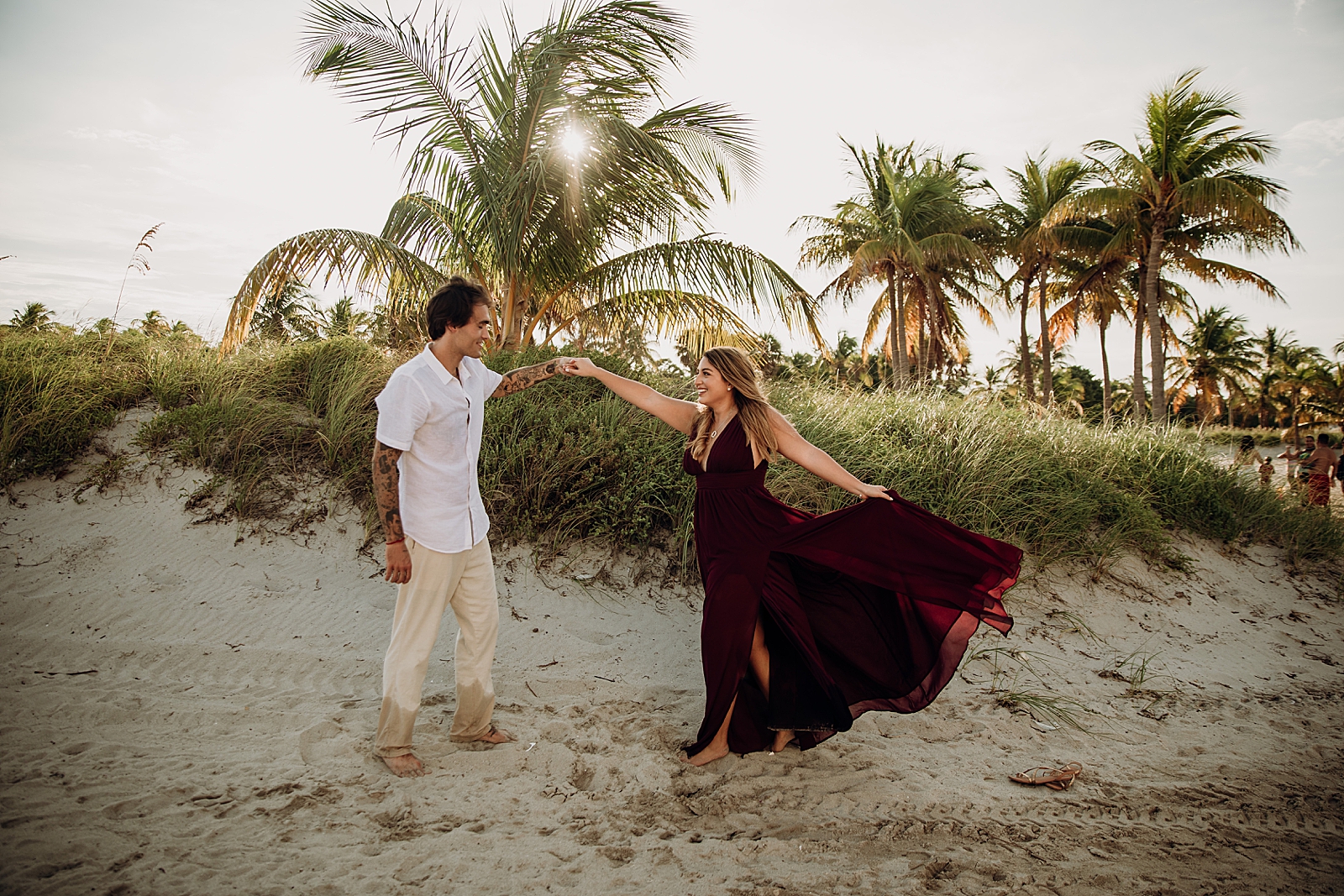 Couple pirouetting on the beach Key Biscayne Beach Engagement Photography captured by South Florida Family Photographer Maggie Alvarez Photography