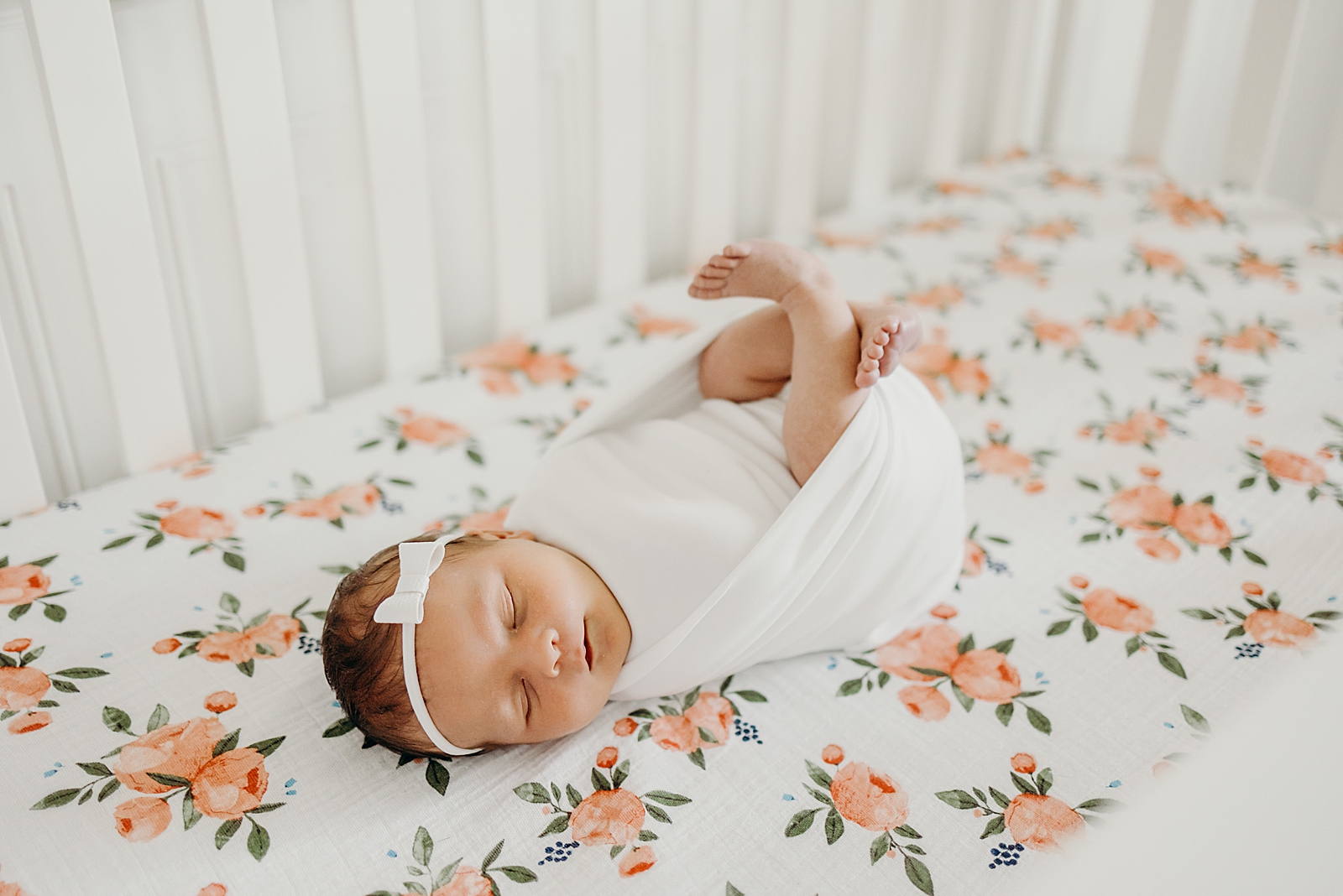 Baby sleeping peacefully on floral mattress in the crib South Florida Newborn Photography Photography captured by South Florida Family Photographer Maggie Alvarez Photography