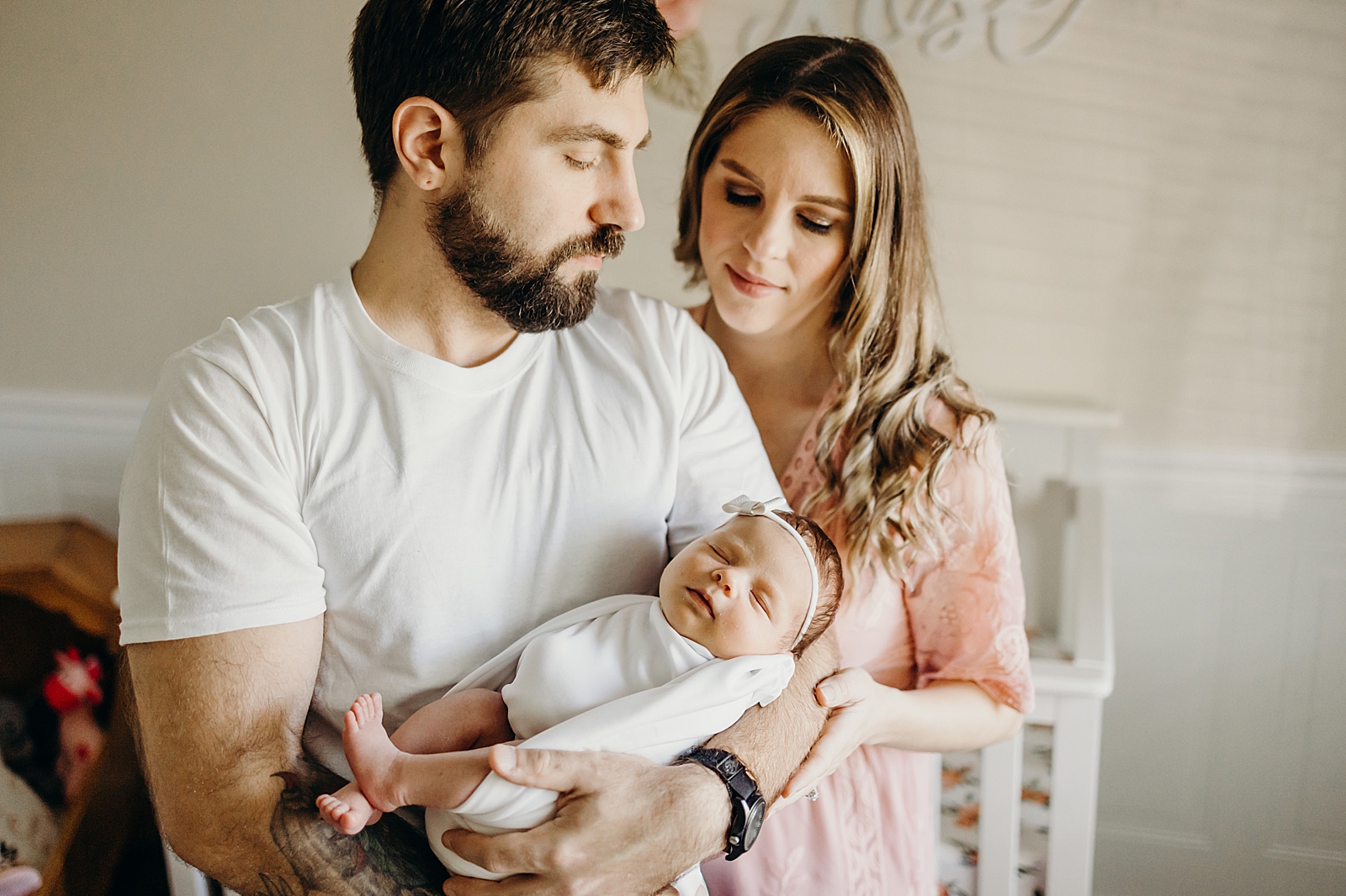Husband holding baby girl with wife holding him South Florida Newborn Photography Photography captured by South Florida Family Photographer Maggie Alvarez Photography
