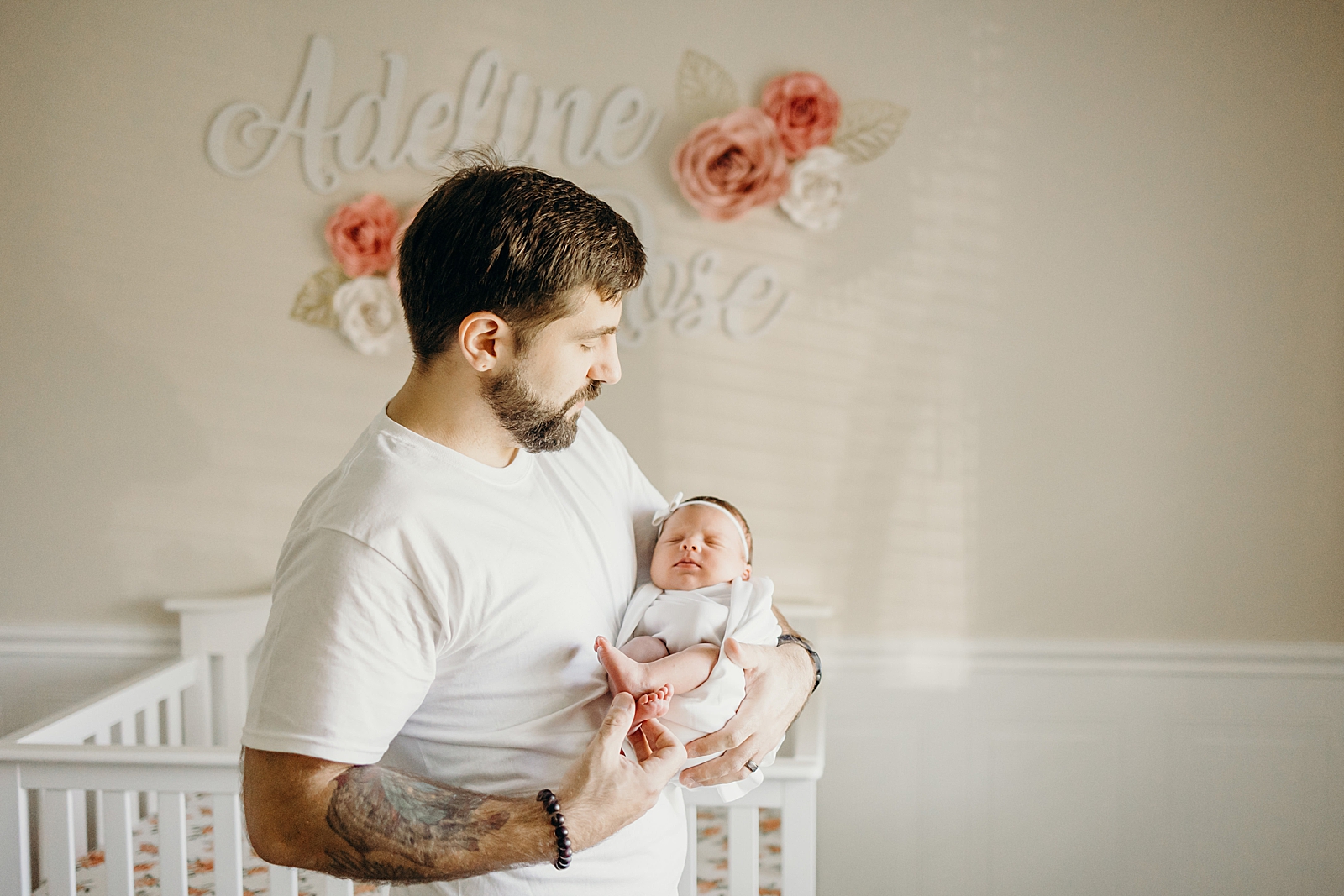 Dad holding newborn toddler in baby room South Florida Newborn Photography Photography captured by South Florida Family Photographer Maggie Alvarez Photography