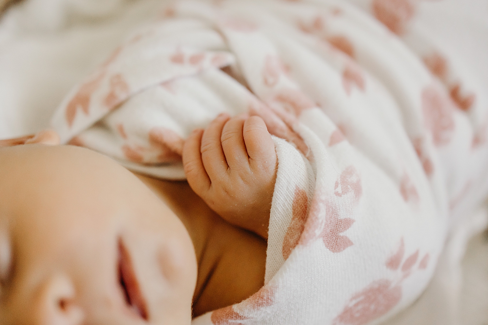 Closeup of baby's hand popping out of floral blanket South Florida Newborn Photography Photography captured by South Florida Family Photographer Maggie Alvarez Photography