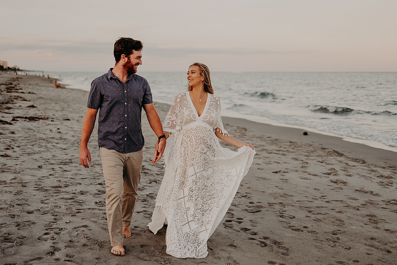 Couple holding hands and walking on the beach Spanish River Park Maternity Photography captured by South Florida Family Photographer Maggie Alvarez Photography