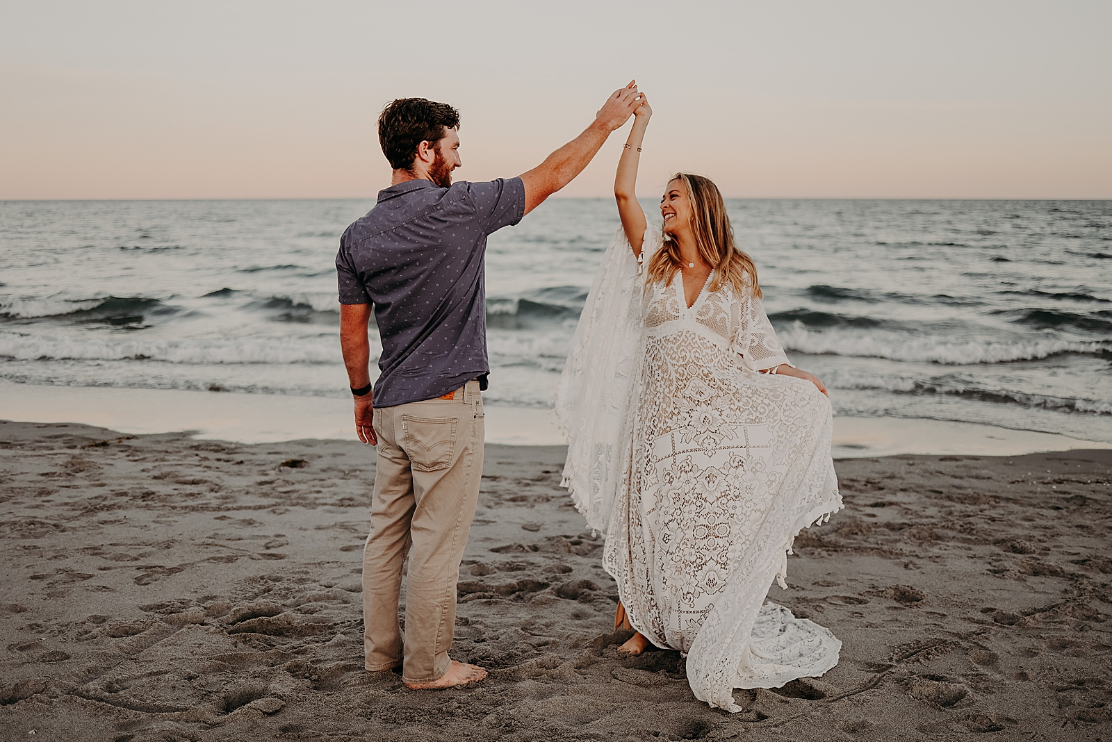Pregnant couple pirouetting on the sand Spanish River Park Maternity Photography captured by South Florida Family Photographer Maggie Alvarez Photography