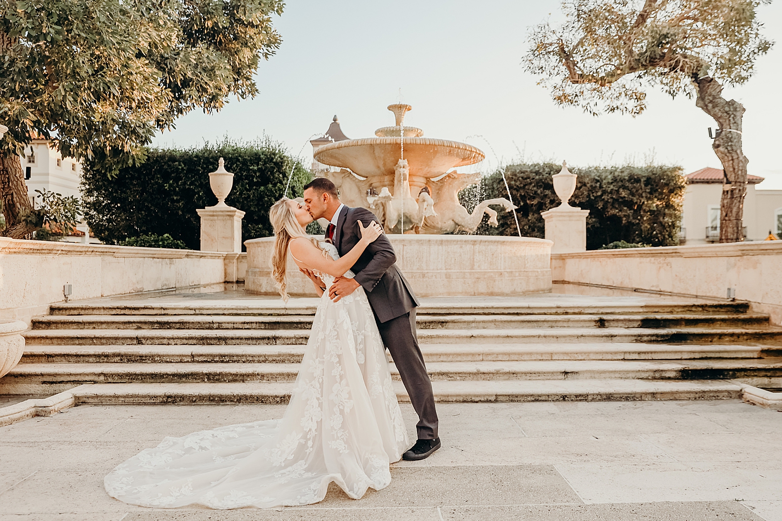 Couple dipping and kissing in front of the water fountain Worth Avenue Bridal Photography captured by South Florida Engagement Photographer Maggie Alvarez Photography
