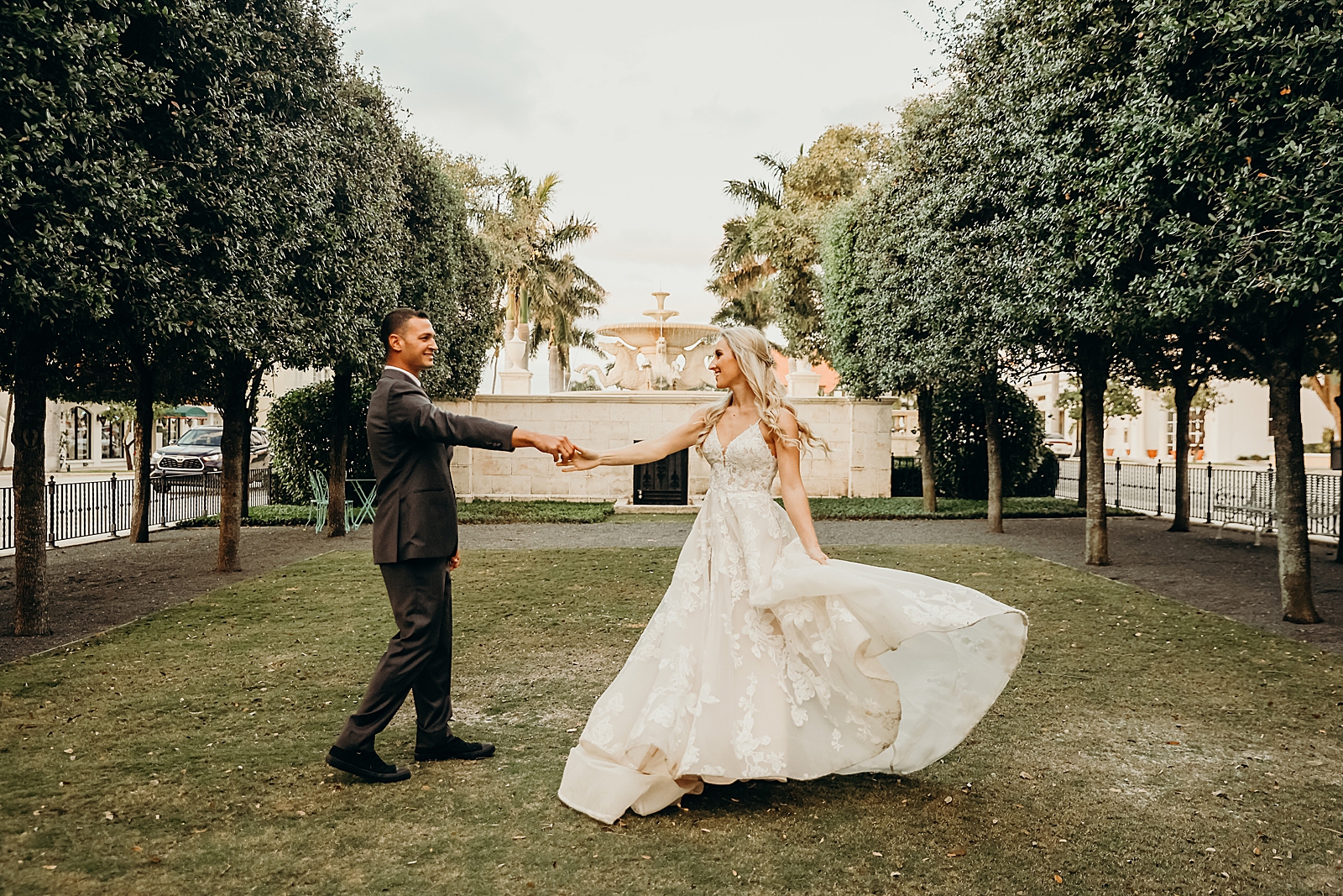 Couple twirling in front of water fountain Worth Avenue Bridal Photography captured by South Florida Engagement Photographer Maggie Alvarez Photography