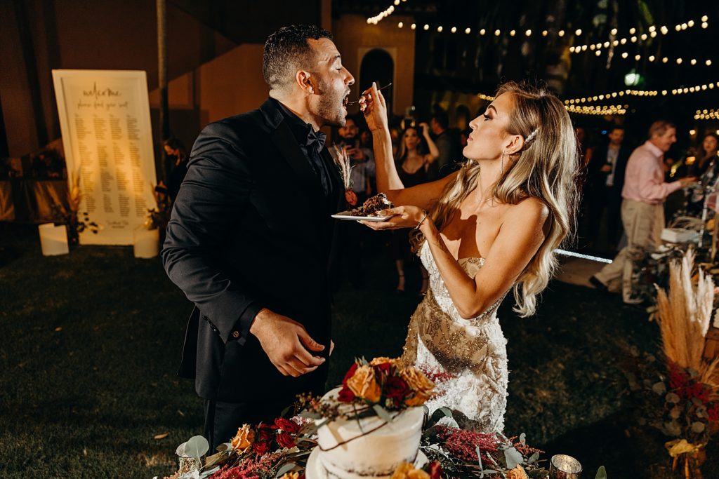 Bride giving a bite of wedding cake to Bride