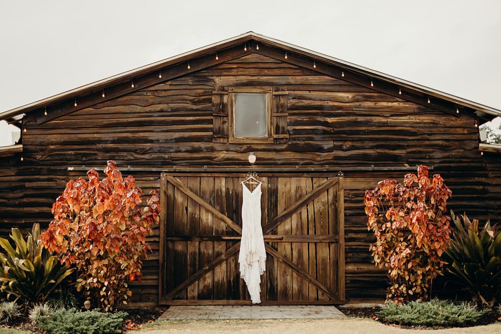 Detail shot of wedding dress hanging on wood cabin