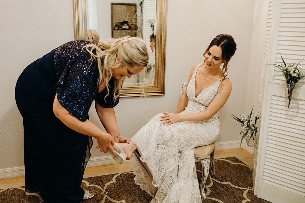 Mother helping Bride put shoes on