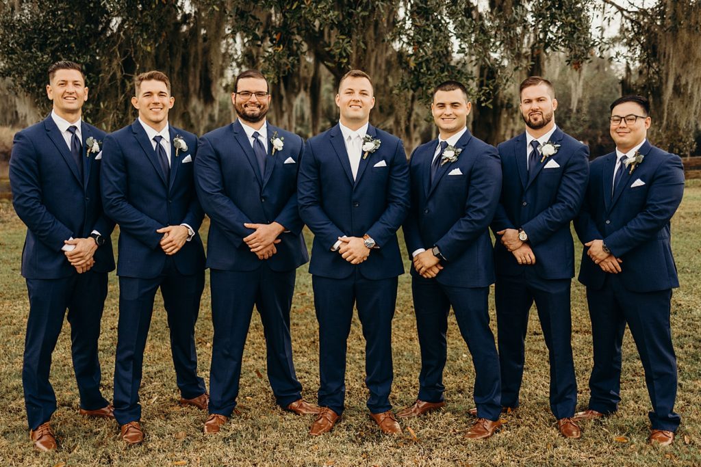 Groom and Groomsmen in formal formation outside on the grass