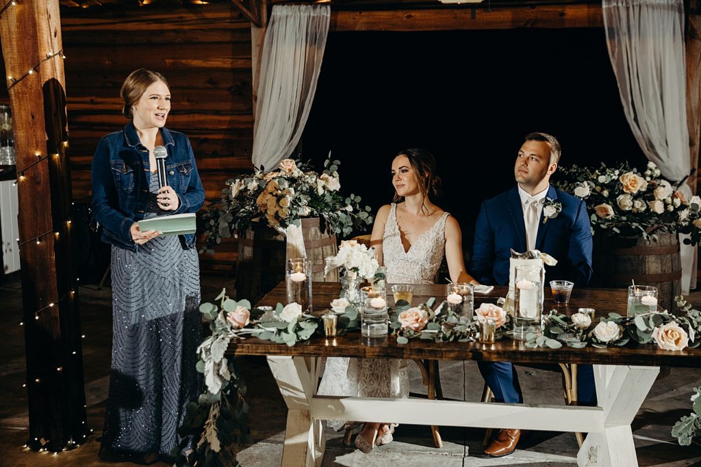 Maid of Honor speech by sweetheart table with Bride and groom