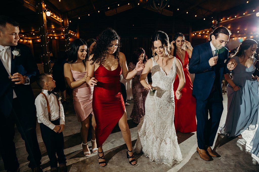 Bride dancing with guests at nighttime Reception