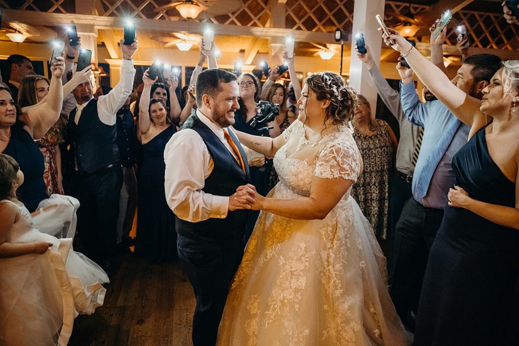 Bride and Groom dancing with guests lighting them with iphone flashlights