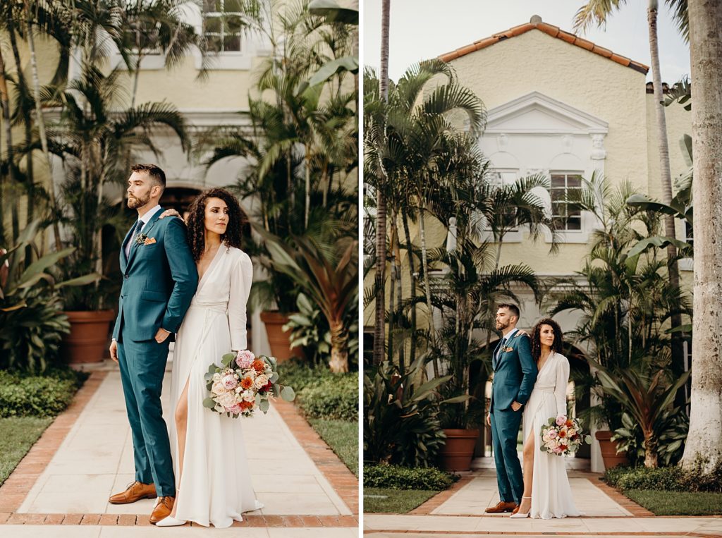 Woman putting hand on man's shoulder and holding bouquet in front of palm trees